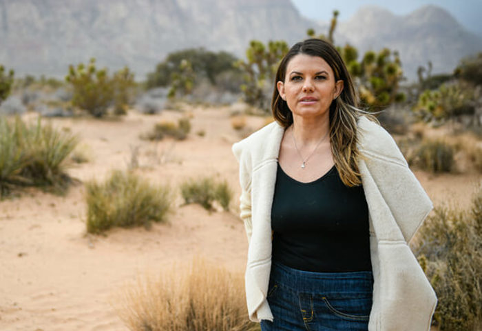 Wounded warrior Melissa McMahon poses in front of a desert background.