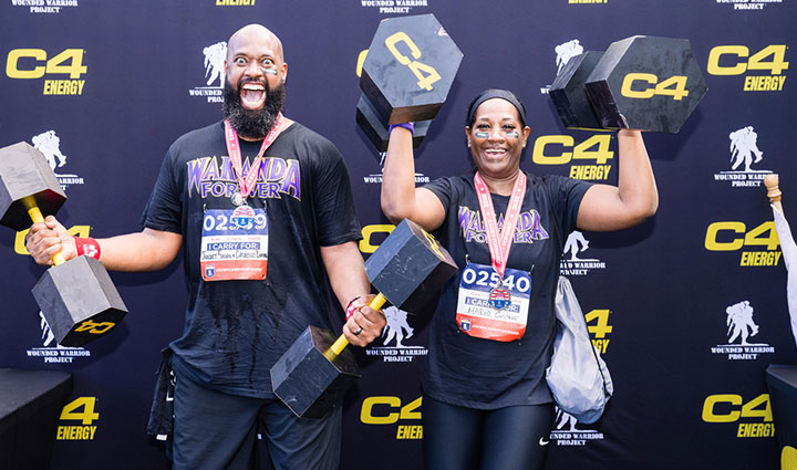 Carry Forward 5K participants posing in front of Nutrabolt's C4 Energy photo backdrop