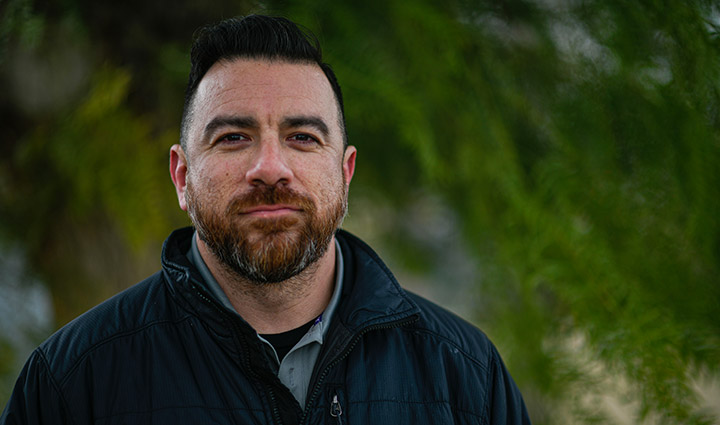 Wounded warrior Arnulfo Dauto stands outside smiling.