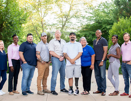 A group of wounded veterans and caregivers from the Warriors Speak team pose together