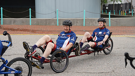 Bob and Garrett Seifert ride a tandem bike in the Soldier Ride 250.