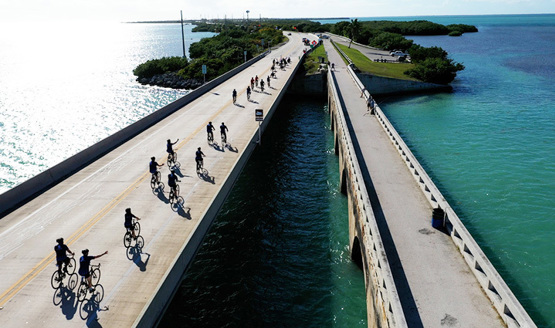 Aerial view of Soldier Ride cyclists crossing a bridge over water on the route from Miami to Key West.
