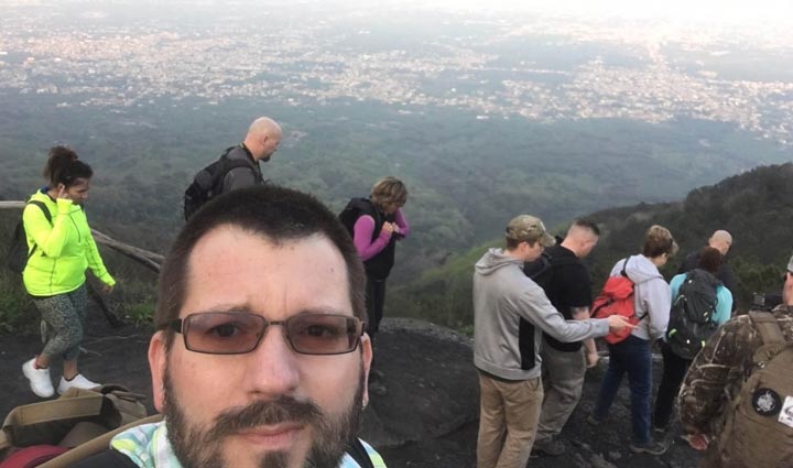 El veterano herido Steven Swiger toma una selfie con varios veteranos detrás.