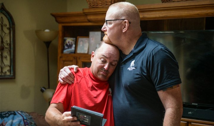 Los veteranos heridos Nick Bennett y Dan Miller prestaron servicio juntos en Iraq y reflexionan sobre el tiempo que compartieron mientras miran un álbum de fotos.