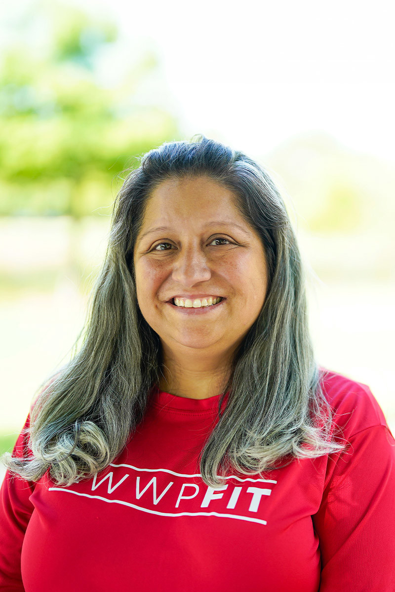 Wounded warrior Maria Edwards smiles at the camera while wearing a red t-shirt.