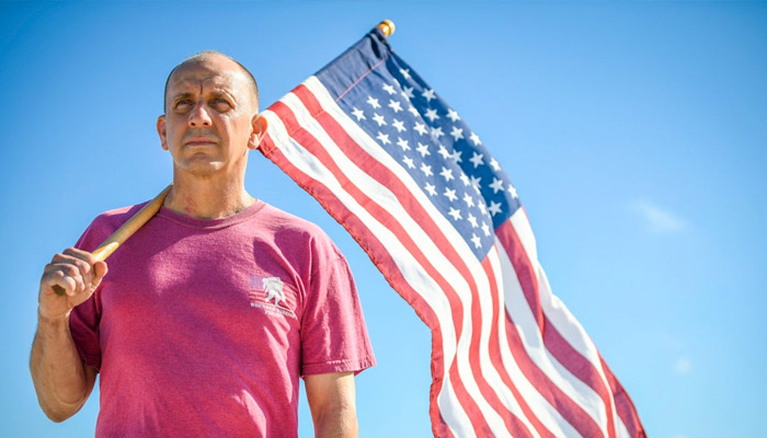 James Rivera holds the American flag over his shoulder