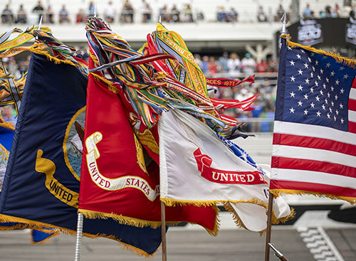 Wind blows the flags of a Military District of Washington Joint Armed Forces Color Guard ahead of the Daytona 500.