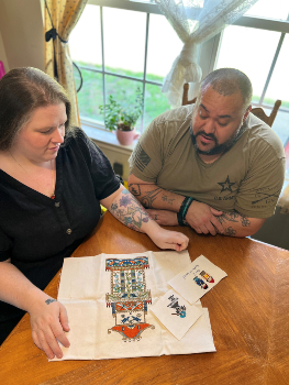 David and his wife admiring some of his cross-stitch projects.