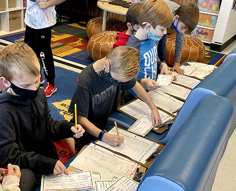 Third-grade students fill out bracelet orders.