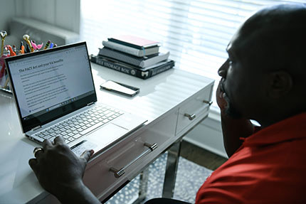 A veteran on the phone and looking at the VA's PACT Act website.