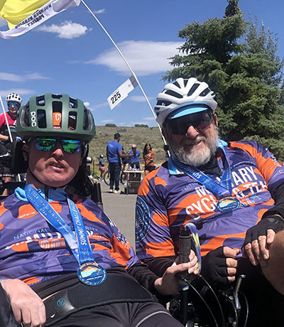 Josh Fohner and Mike Fohner on a side-by-side recumbent bike.