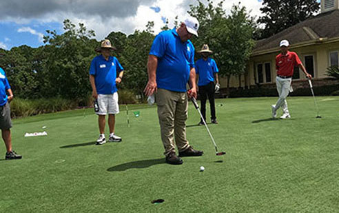 Veterabn Ozzie Nelson lines up a putt during a PGA Tour golf clinic.