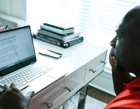 Warrior Melvin Gatewood reviews information on The PACT Act on his computer.