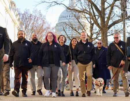 A group of WWP warriors walks toward the camera with the US Capitol building in the background. 