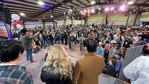 Auctioneer takes bids at the annual employee conference for Allcat to raise money for Wounded Warrior Project.