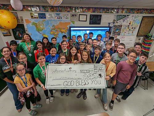 Sixth-grade students in teacher Ben Lewis' class raise money for Wounded Warrior Project by writing and selling books about the American experience.