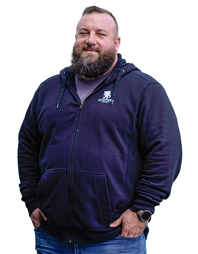 Wounded warrior Matthew Templeton stands outside smiling while wearing a black Wounded Warrior Project hoodie.