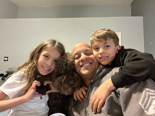 Marine veteran Juan Valdez with two of his children and the family dog.